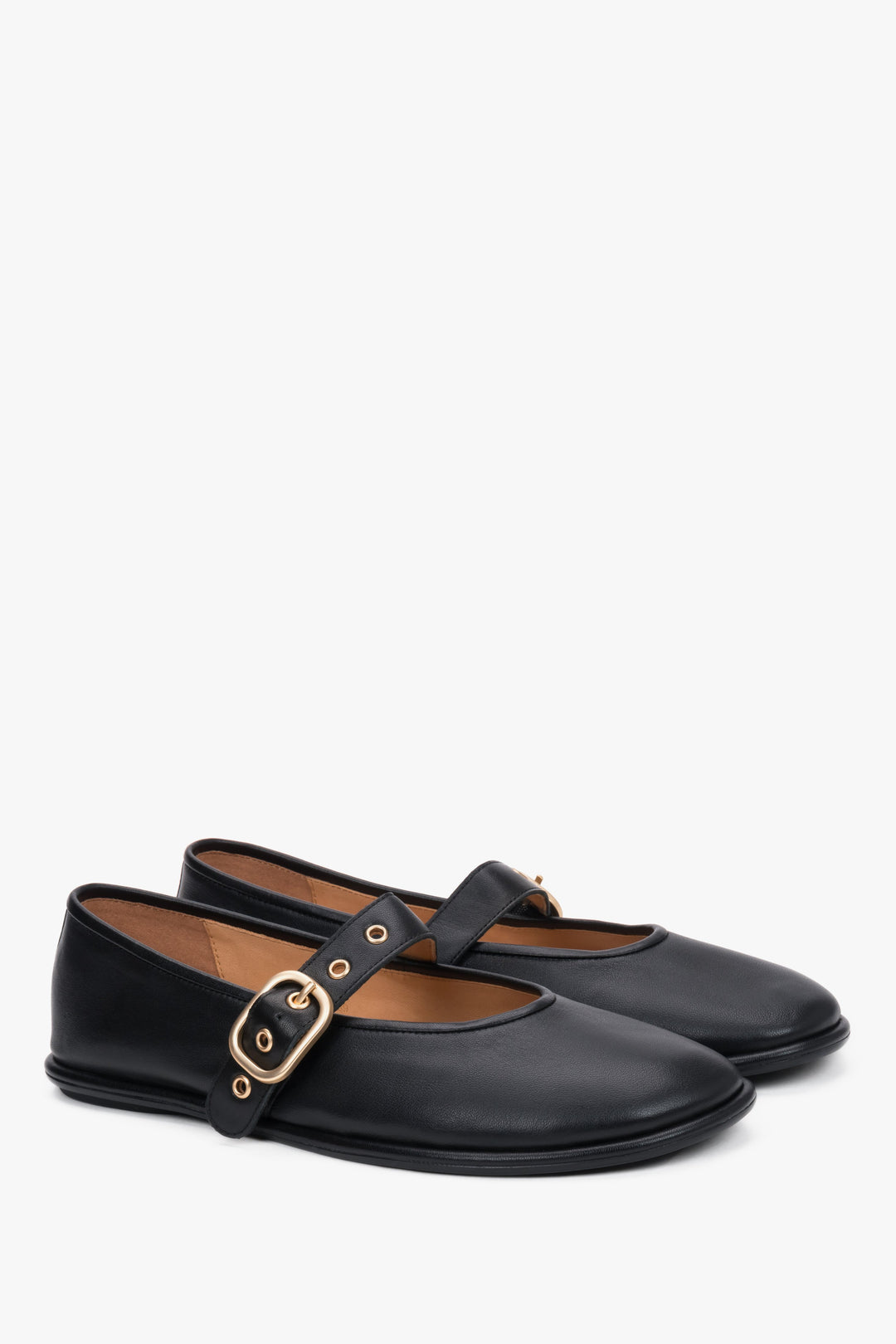 A profile shot of the black leather ballet flats highlighting the slim, flat rubber sole and the elegant positioning of the adjustable ankle strap.