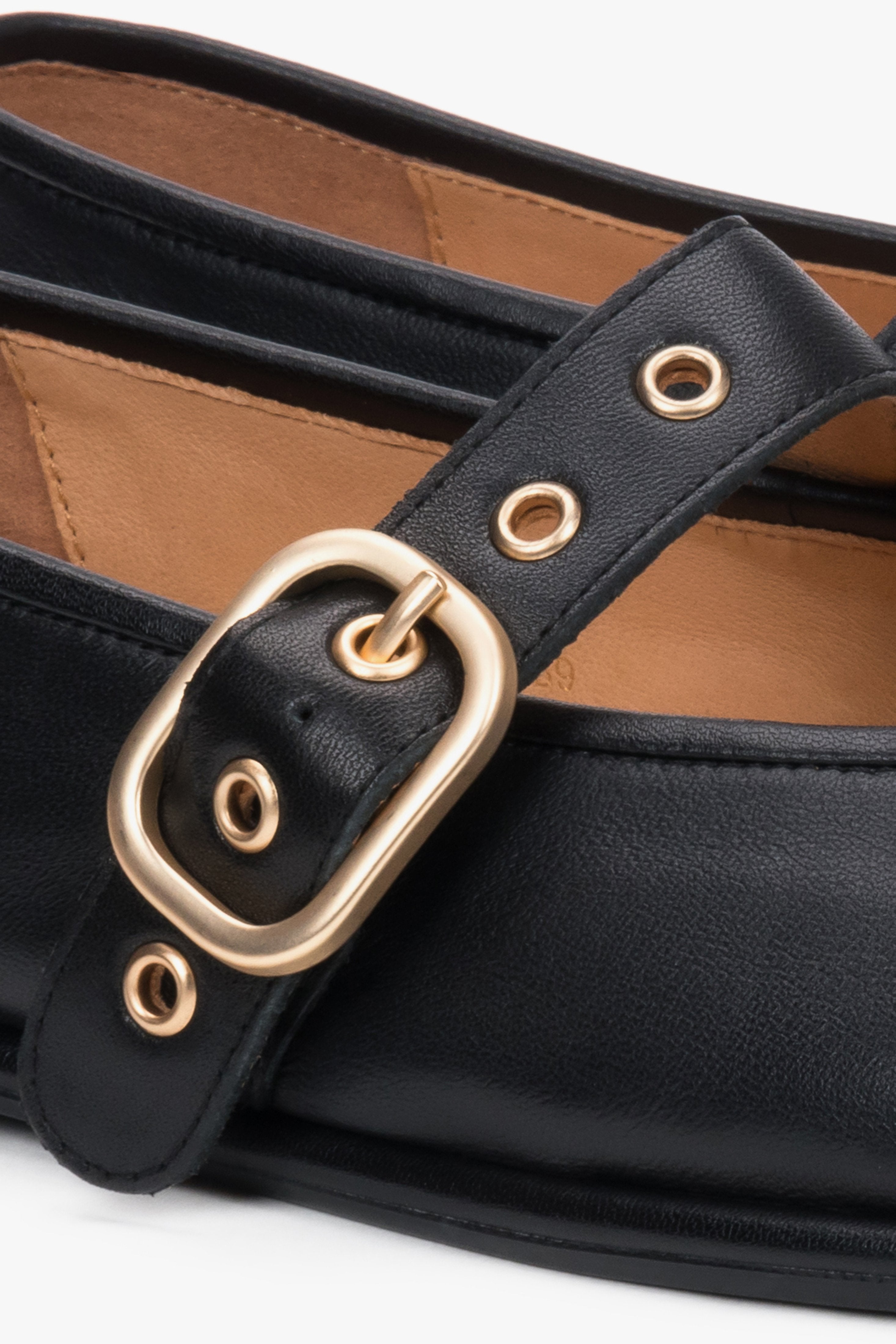A close-up shot focusing on the high-quality, smooth black leather texture and the polished brilliance of the golden buckle closure.