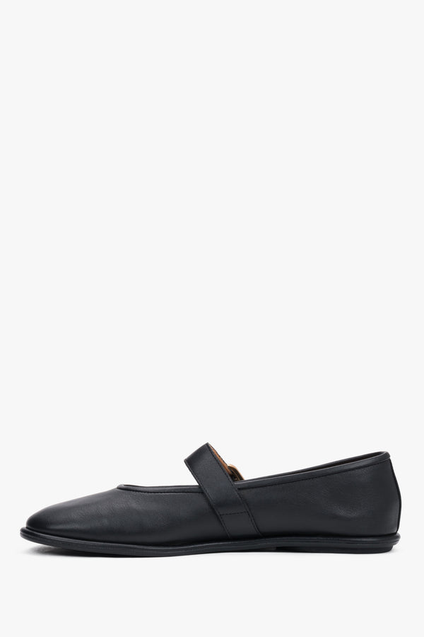A profile shot of the black leather ballet flats highlighting the slim, flat rubber sole and the elegant positioning of the adjustable ankle strap.