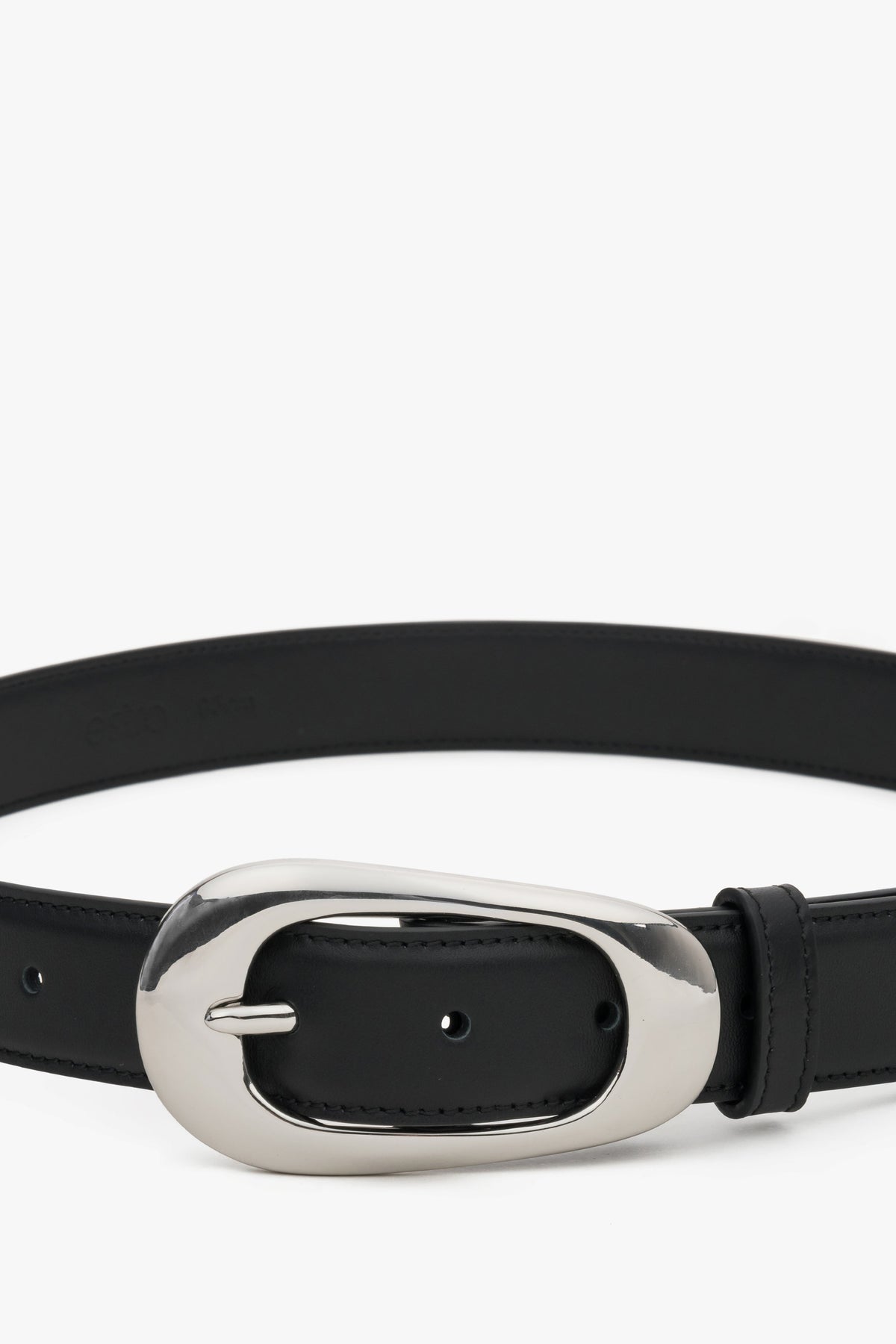 Close-up of the large oval buckle on a black leather belt.