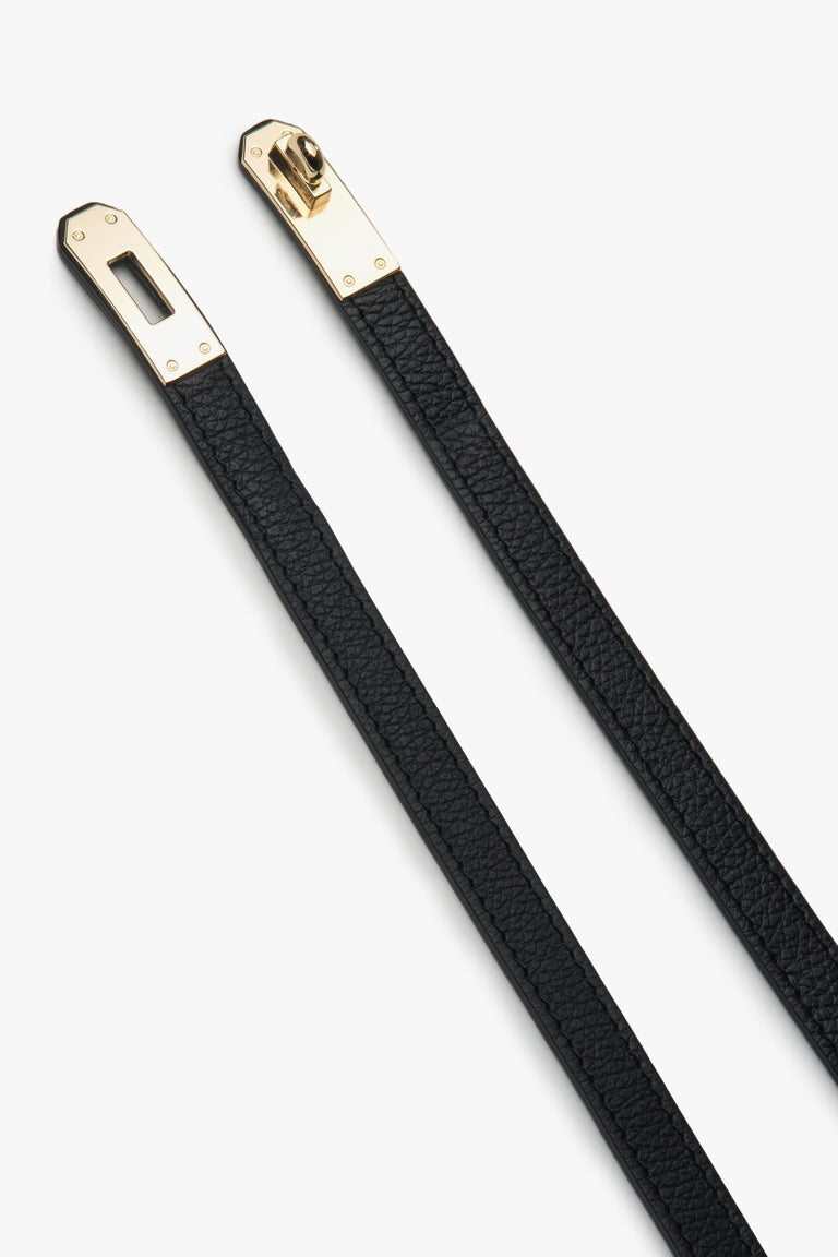 Elegant black leather belt from Estro, measuring 95 cm in length, shown styled around the waist to complement a chic outfit.