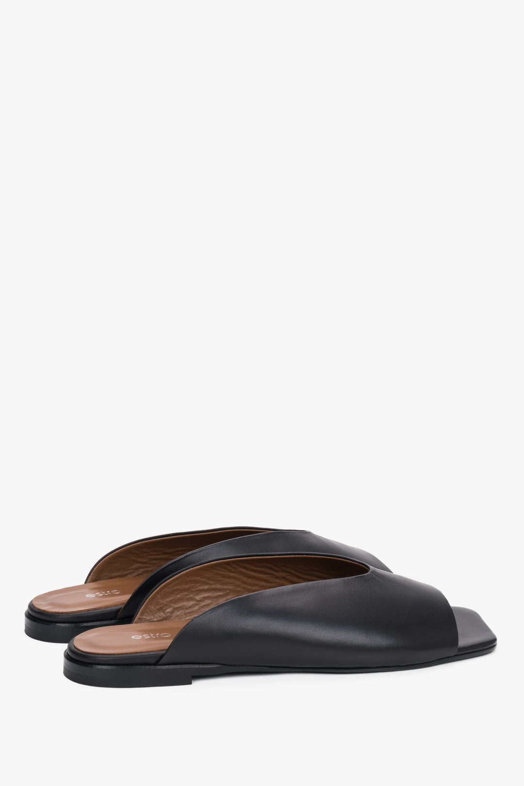 Angled view of women's black leather mules with TPU sole