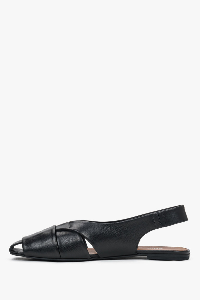 Profile of black leather sandals with open heel and flat sole.