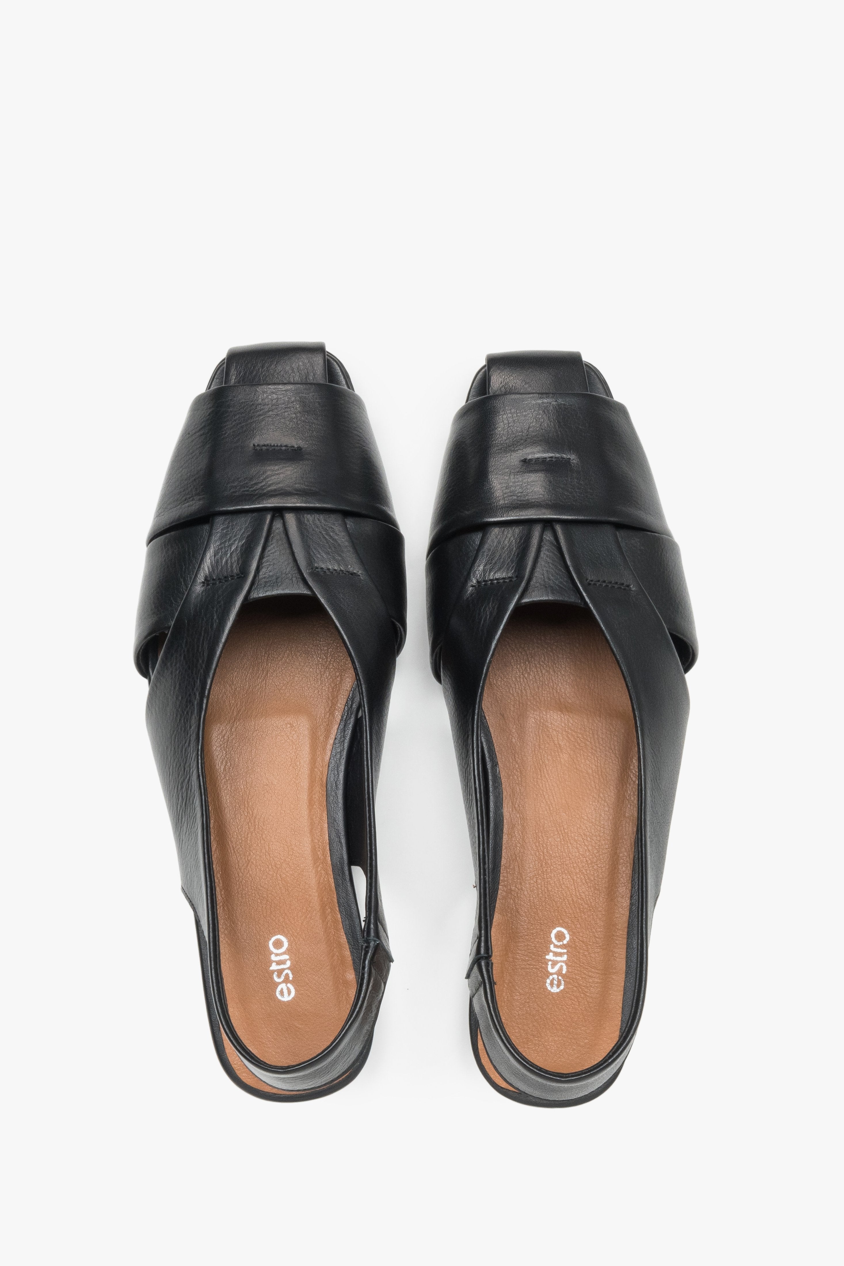 View from above of black leather sandals with covered toes.