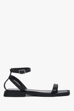 Women’s black leather flat sandals by Estro with thin straps.