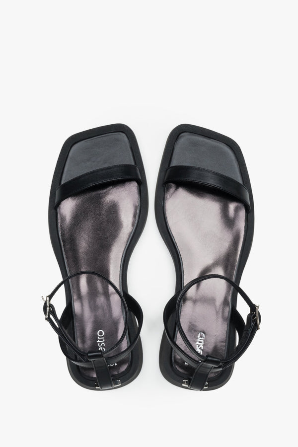Top view of women’s black flat sandals with slim leather straps.