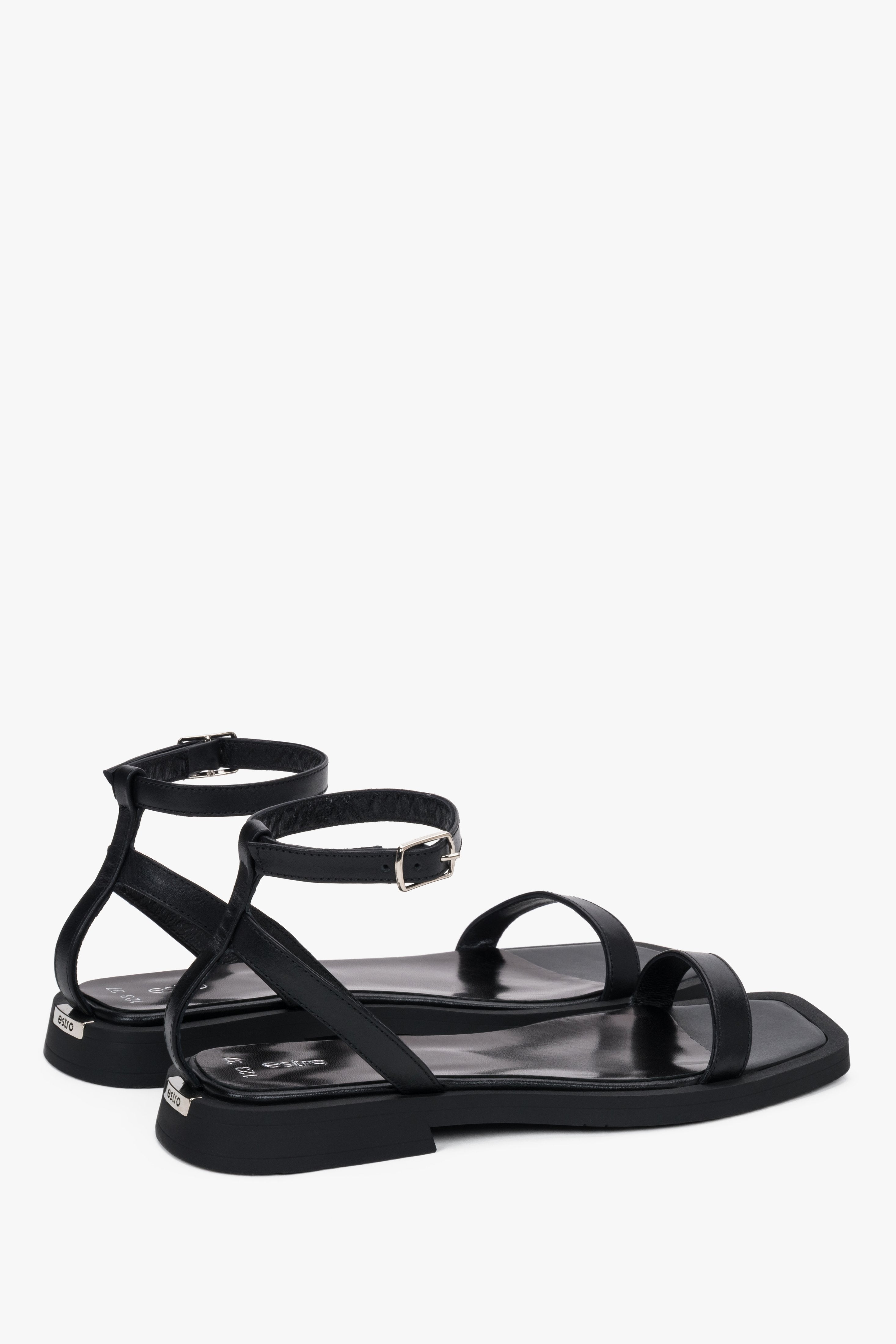 Detail view of the thin straps and soft black leather on Estro sandals.