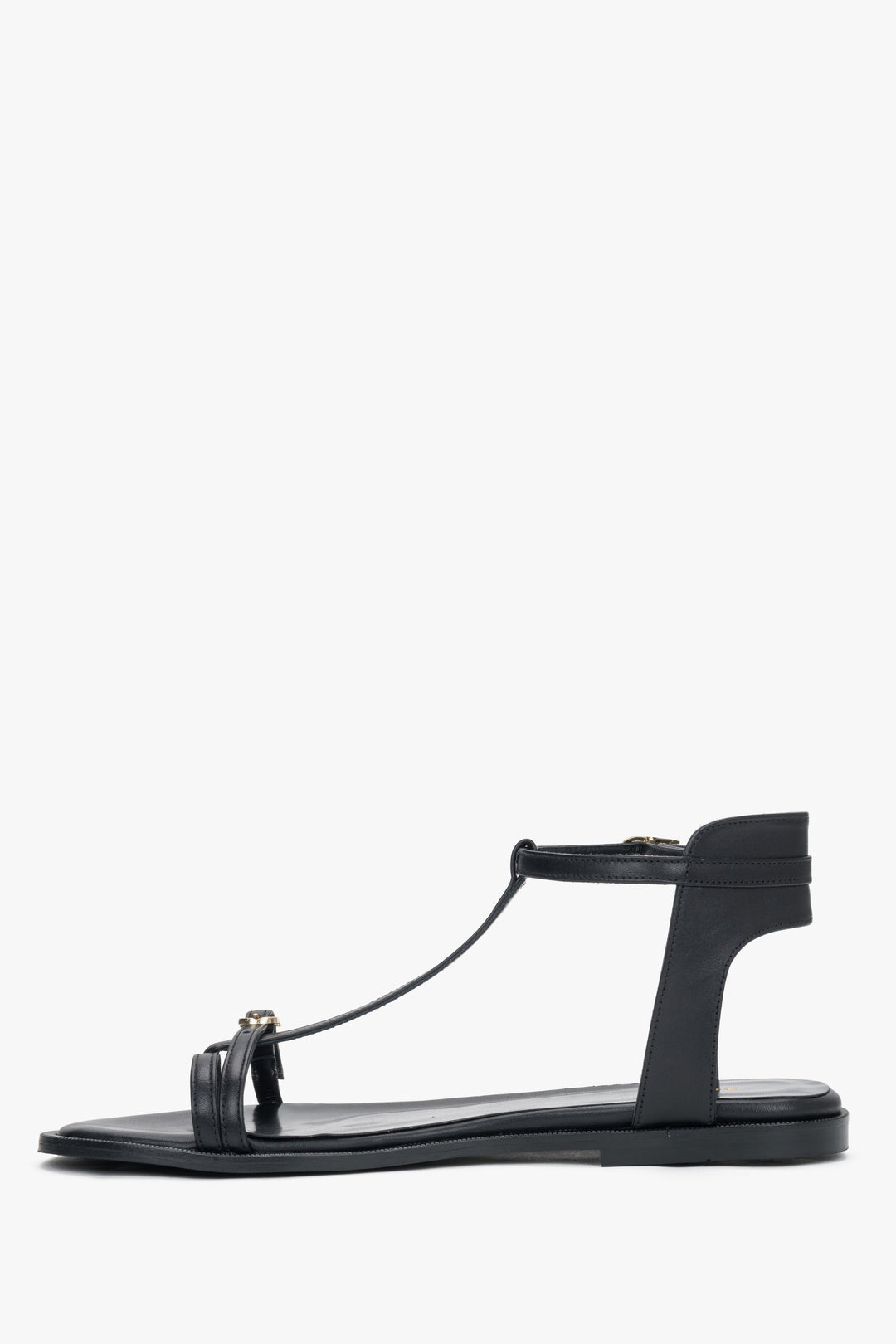 Side view of women's black leather flat sandals with T-strap
