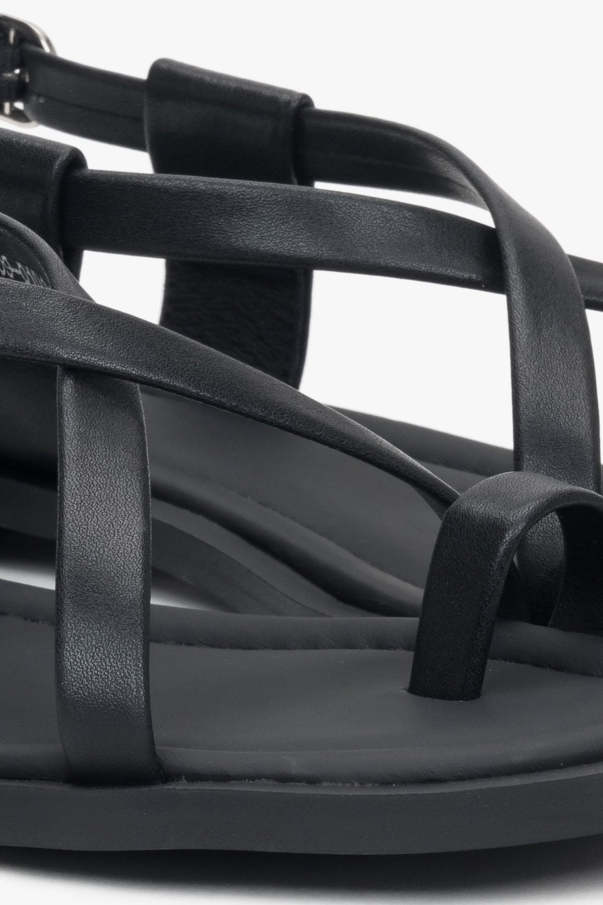Black women’s leather sandals by Estro on a flat sole with a toe loop.