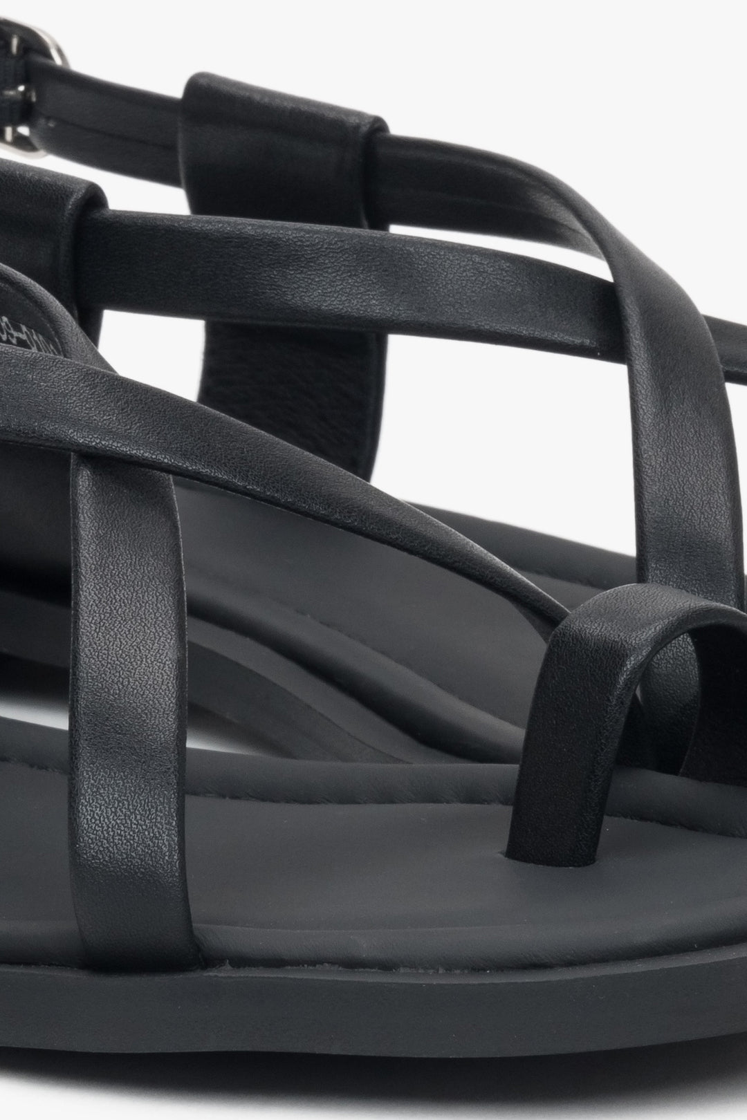 Black women’s leather sandals by Estro on a flat sole with a toe loop.