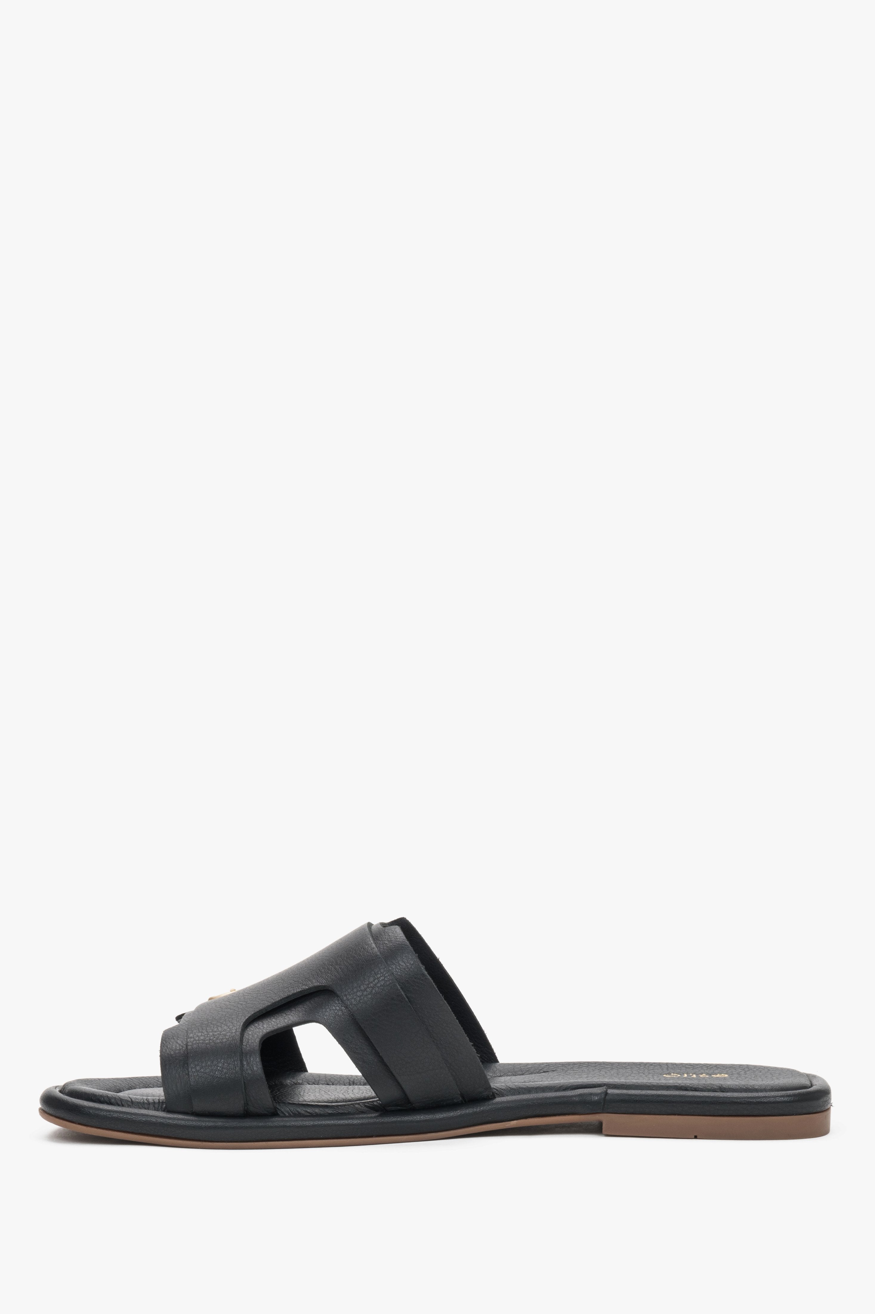 A profile shot of the black leather slides highlighting the flat, flexible TPU sole and the secure, wide strap construction.