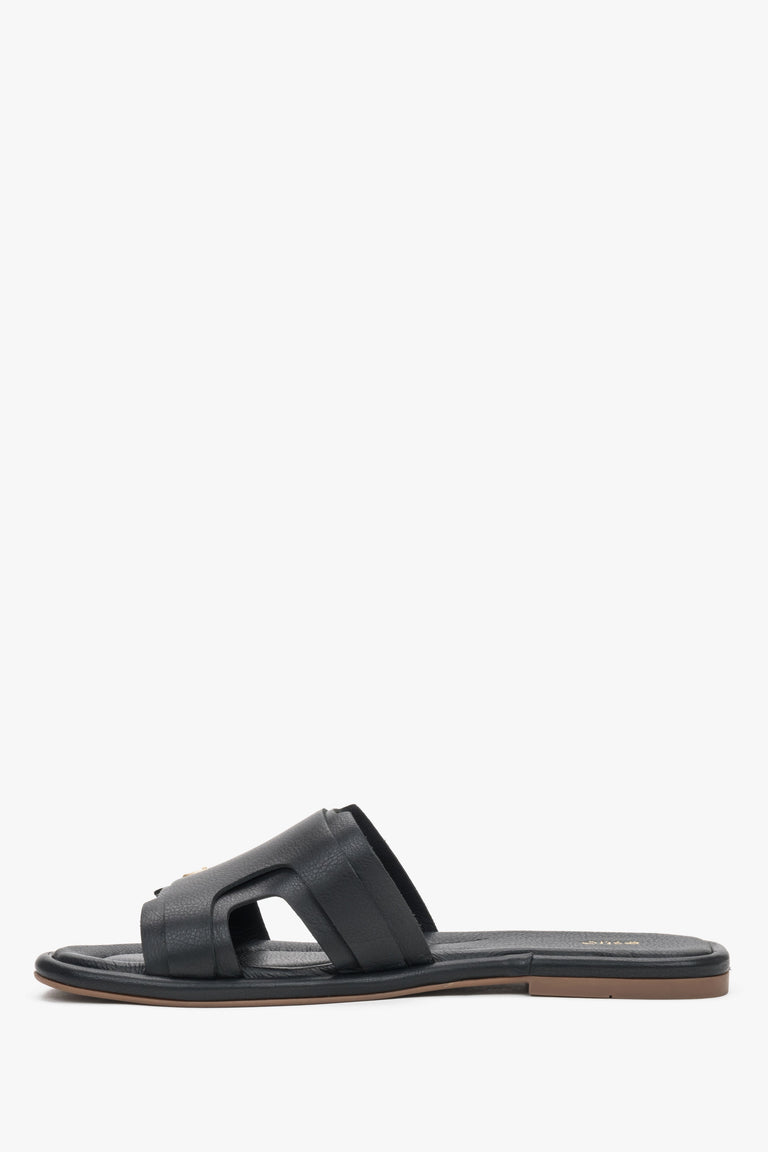 A profile shot of the black leather slides highlighting the flat, flexible TPU sole and the secure, wide strap construction.