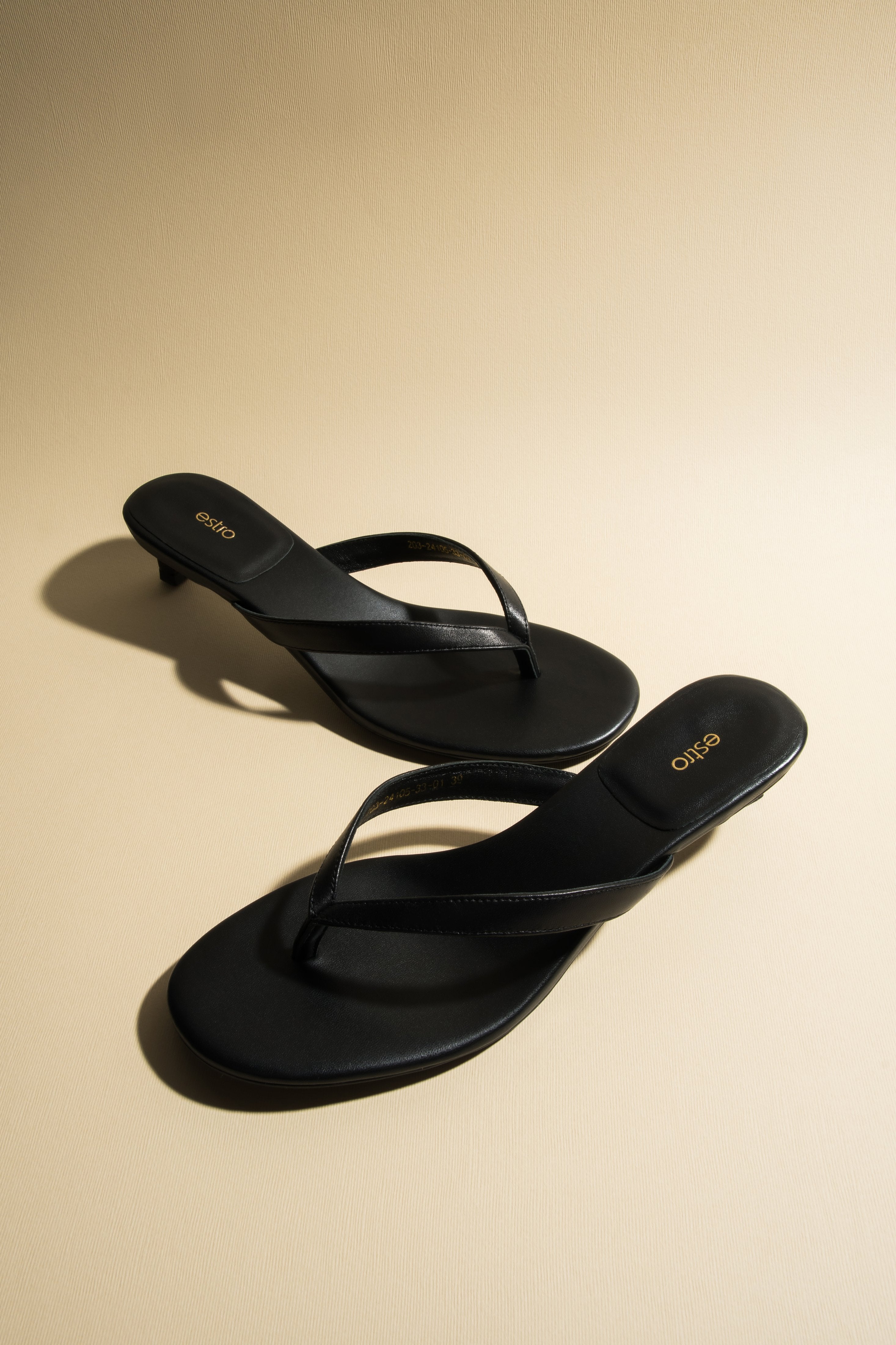 Women’s black leather thong sandals with a low heel by Estro.
