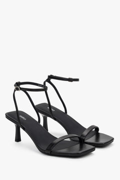 Side view of women's black leather sandals with stable funnel heel.