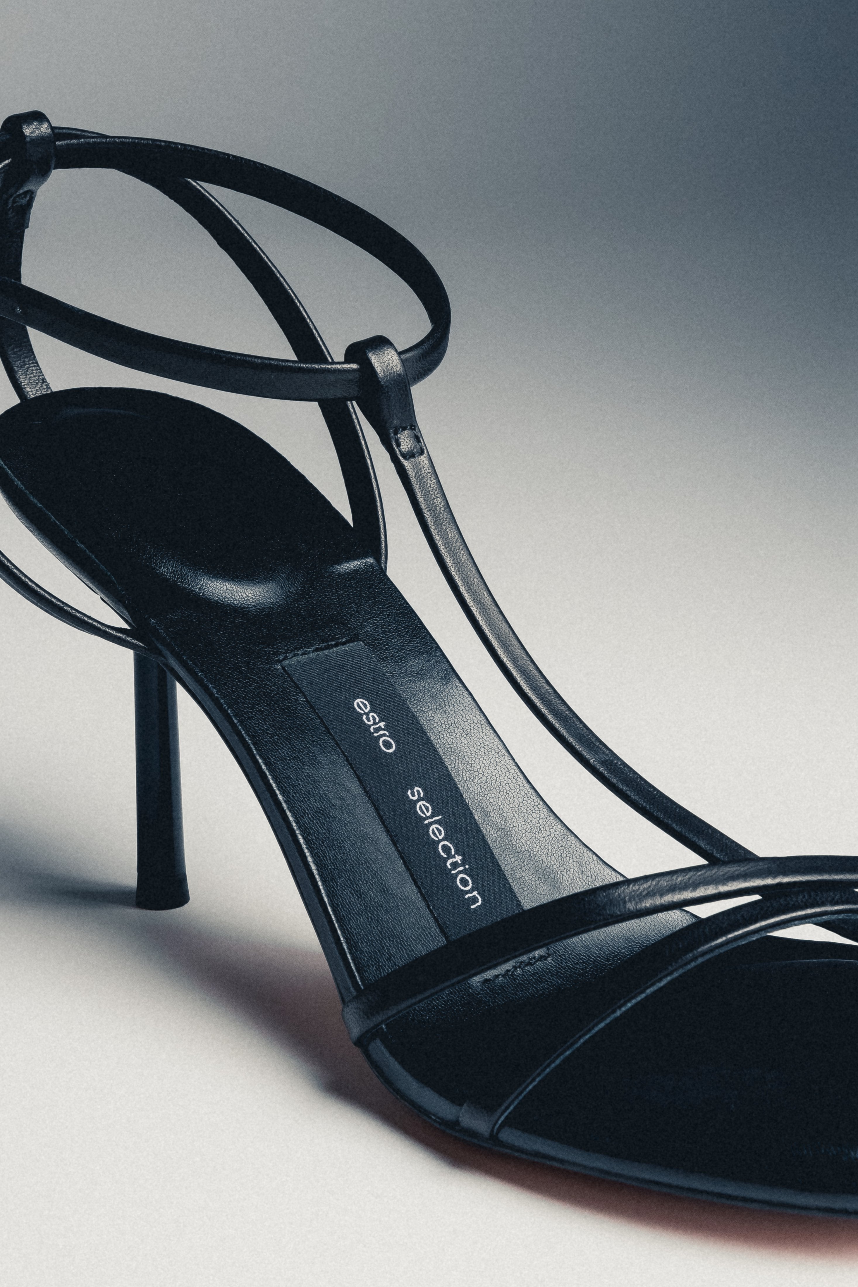 Close-up of women's black leather high heel sandals with buckle