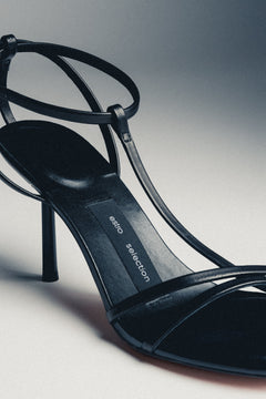 Close-up of women's black leather high heel sandals with buckle