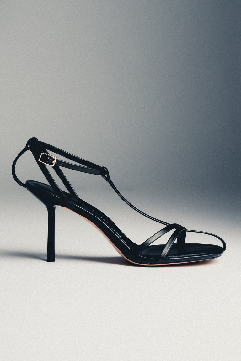 Women's black leather high heel sandals styled with Estro packaging