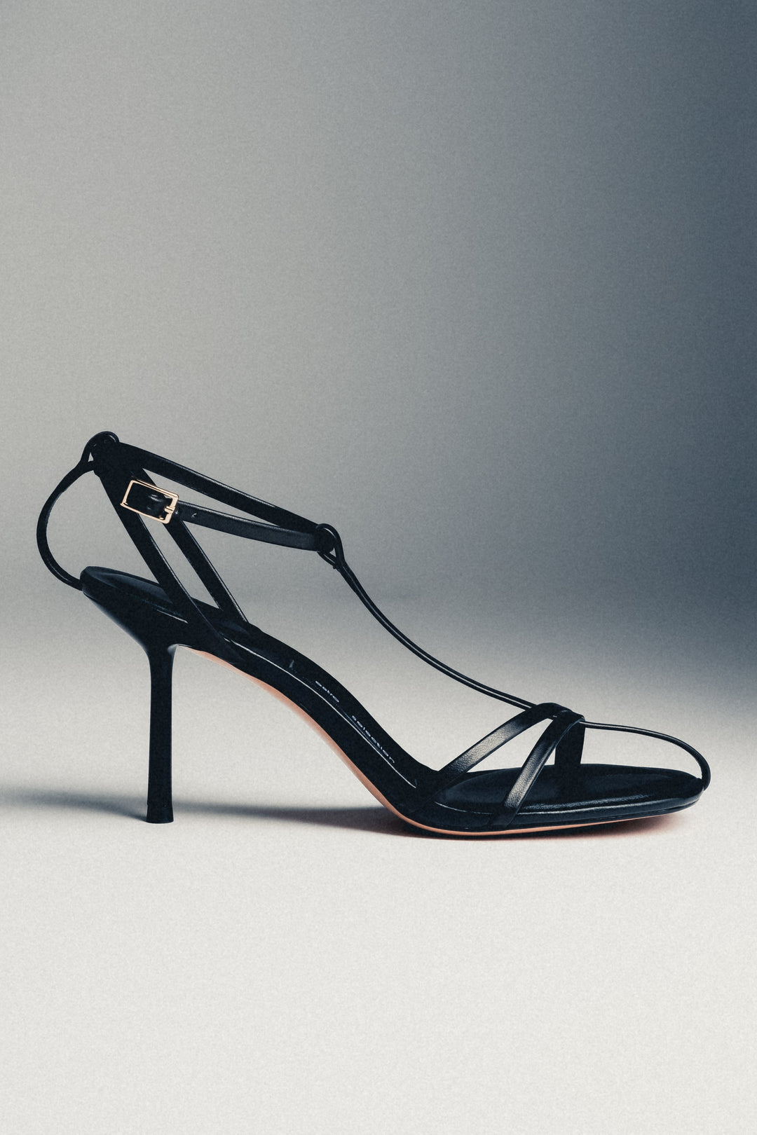 Women's black leather high heel sandals styled with Estro packaging