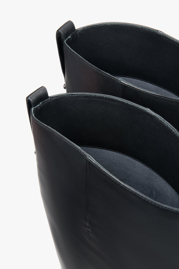 Black women’s leather knee-high boots with a wide shaft – full outfit look.