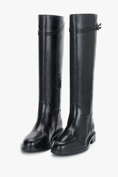 Women's black leather knee-high riding boots Estro - front view showing the sleek silhouette and buckle detail.