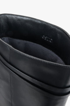 Women's black leather riding boots Estro - close-up view showing the genuine leather texture and hardware detailing.