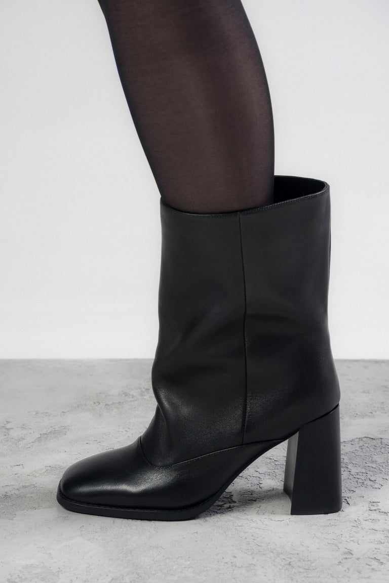 Low black ankle boots with a loose shaft made of natural leather.