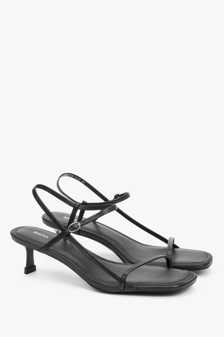 Women’s black leather low-heel sandals with thin straps by Estro.