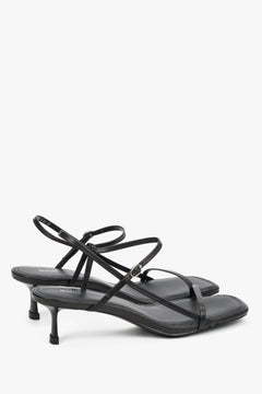 Women’s black leather low-heel sandals by Estro with thin straps.