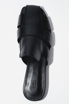 Backless pair of mules showcasing an interlaced front design, a fashionable square toe, and a smooth black insole featuring the brand logo.