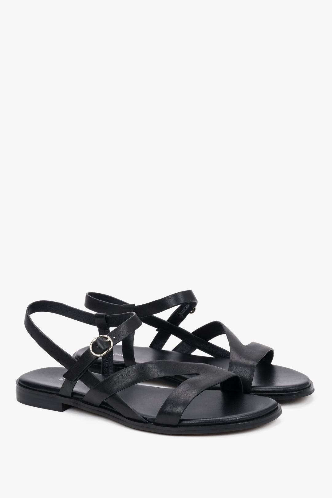 Black women’s leather sandals with crisscross straps and a flat sole.