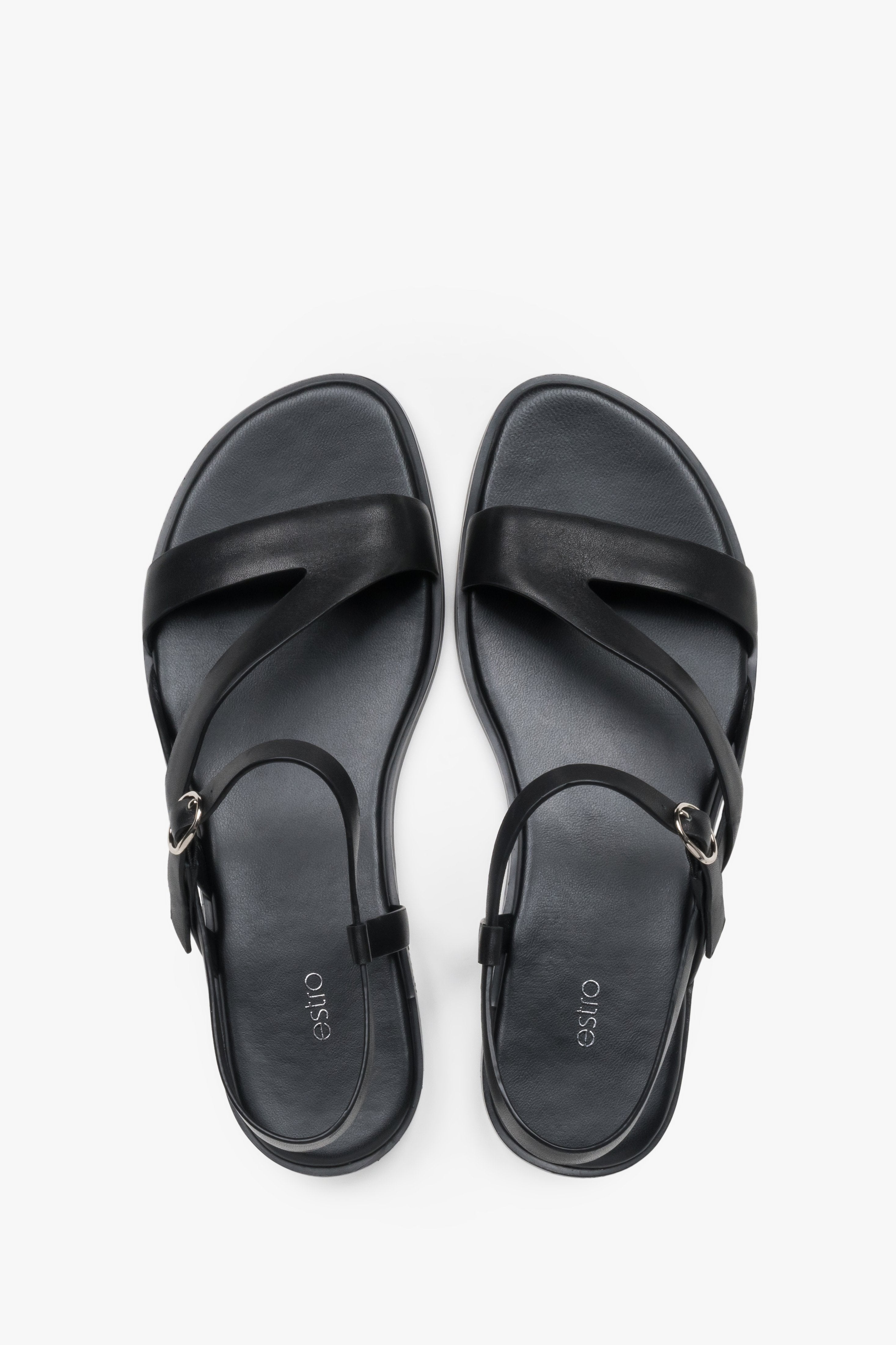Women’s black Estro leather sandals with crisscross straps and a flat sole.