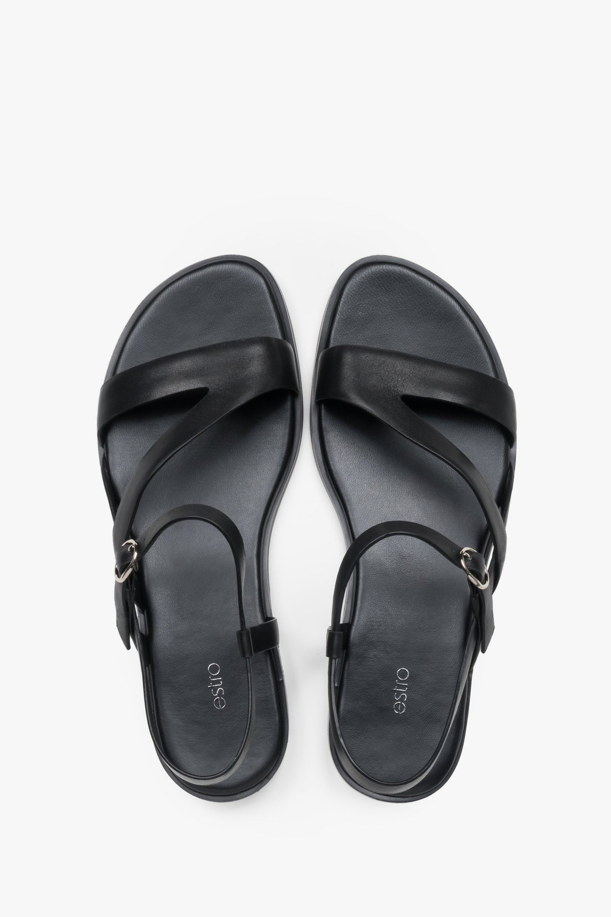 Women’s black Estro leather sandals with crisscross straps and a flat sole.
