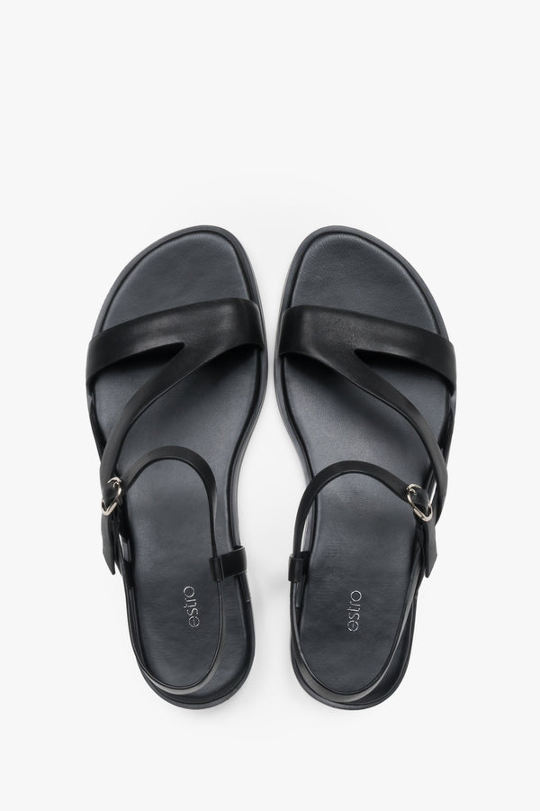 Women’s black Estro leather sandals with crisscross straps and a flat sole.