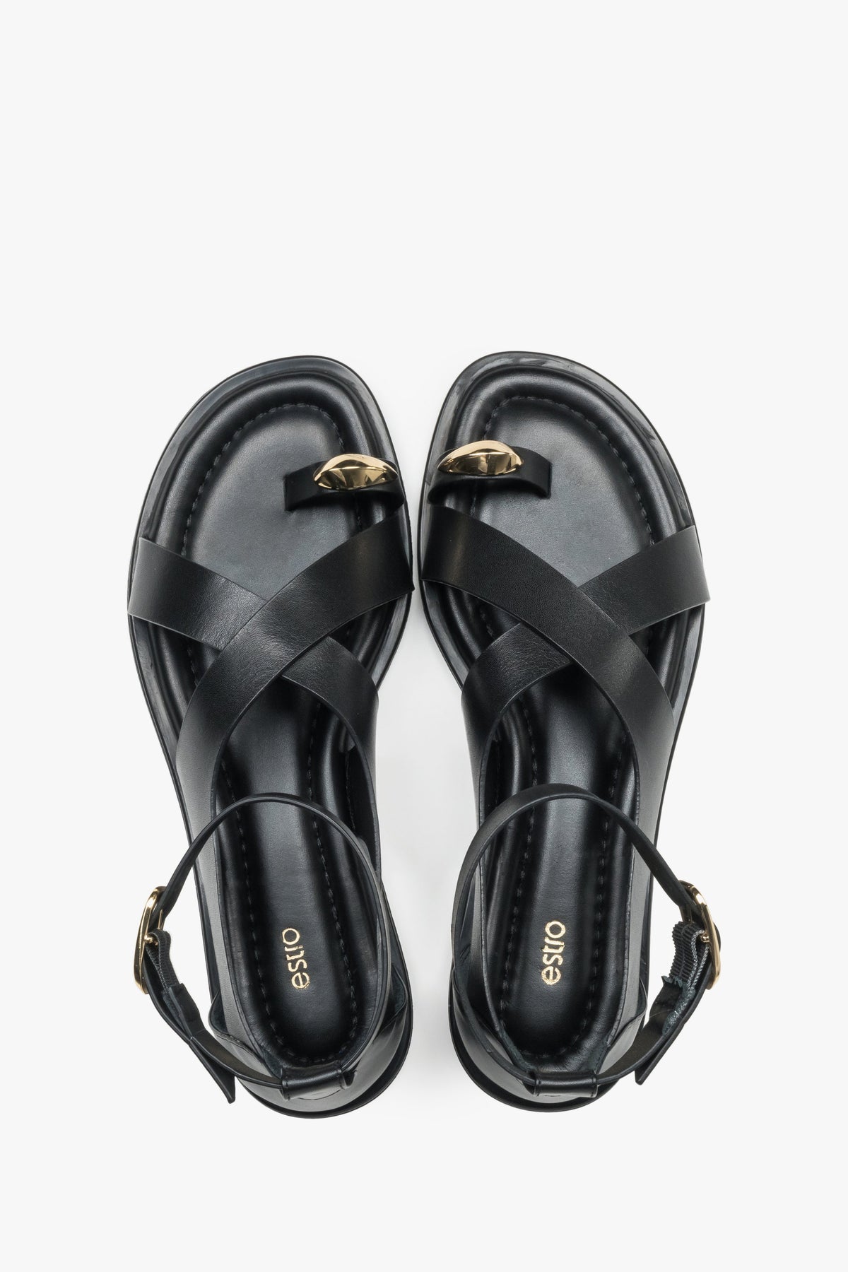 Top view of black leather Estro women’s sandals featuring a gold toe ring detail.