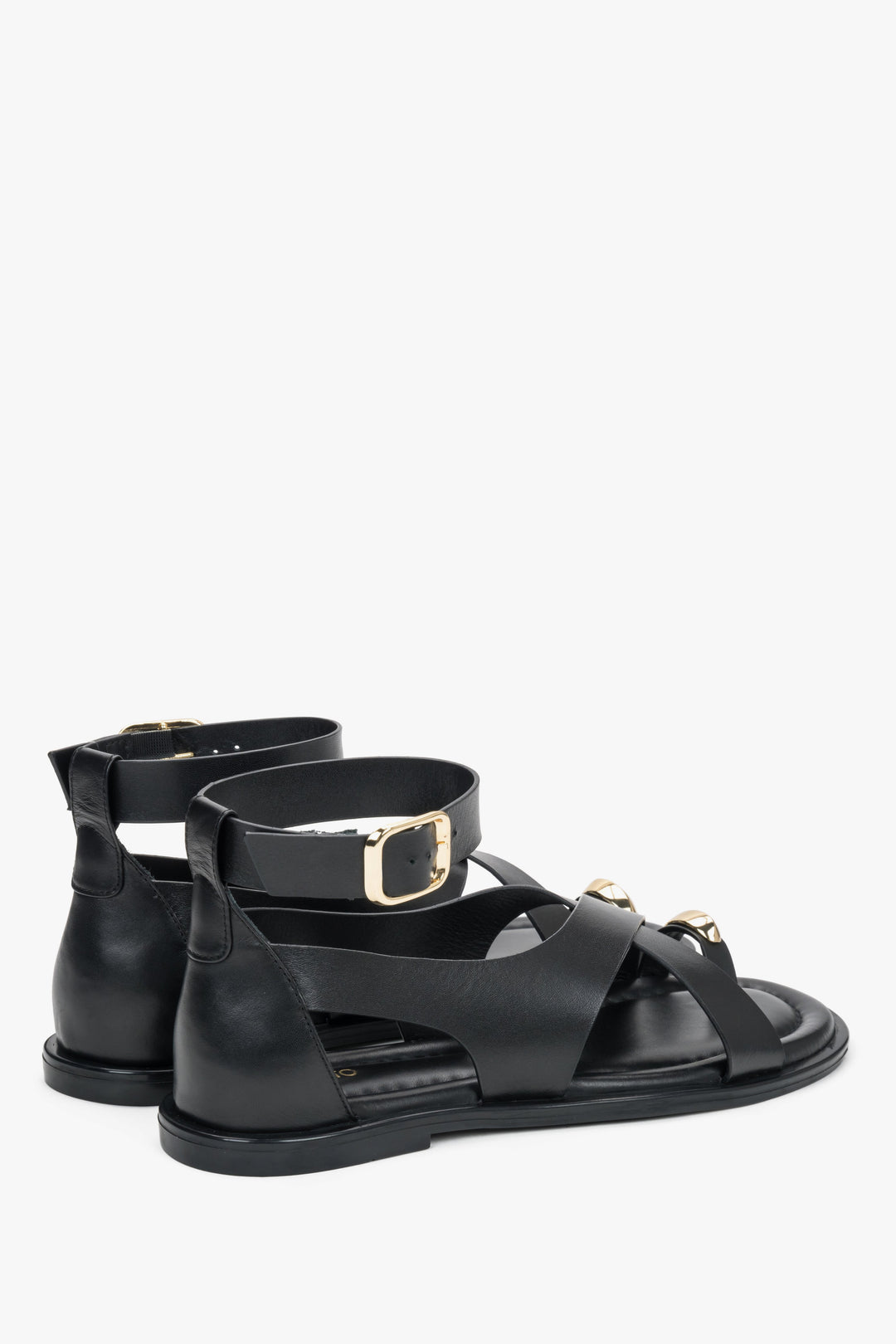 Black leather women’s Estro sandals with a gold toe ring detail.