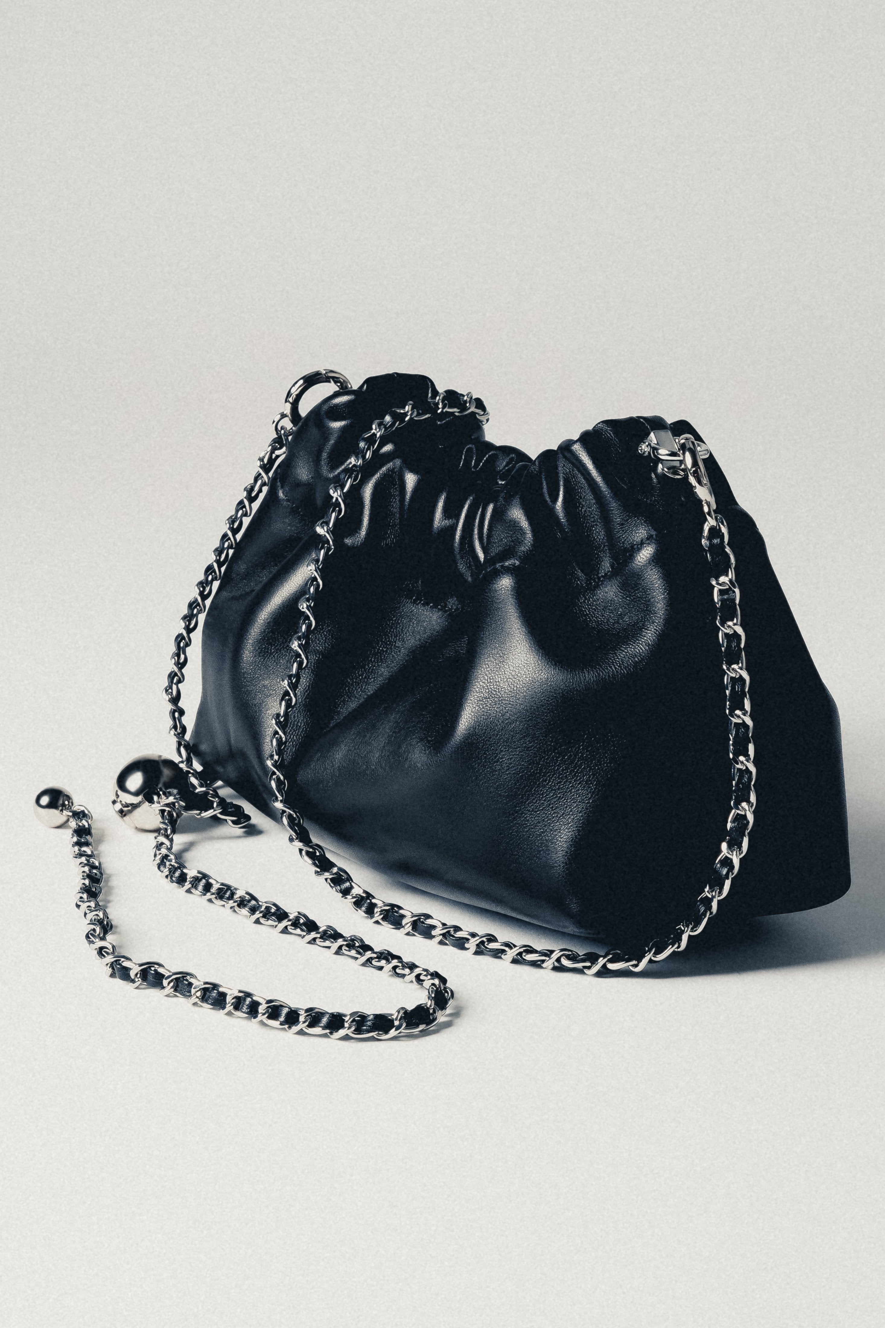 Women's black leather shoulder bag with long silver chain strap
