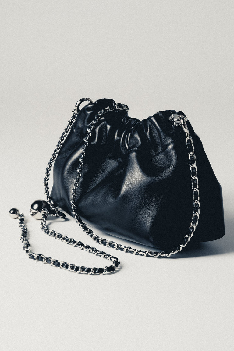 Women's black leather shoulder bag with long silver chain strap