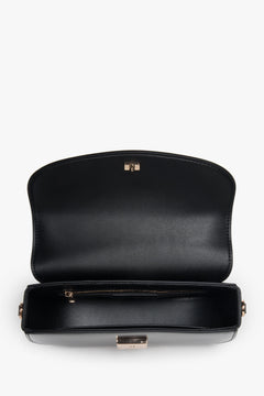 Versatile black shoulder bag with additional adjustable strap for crossbody wear.