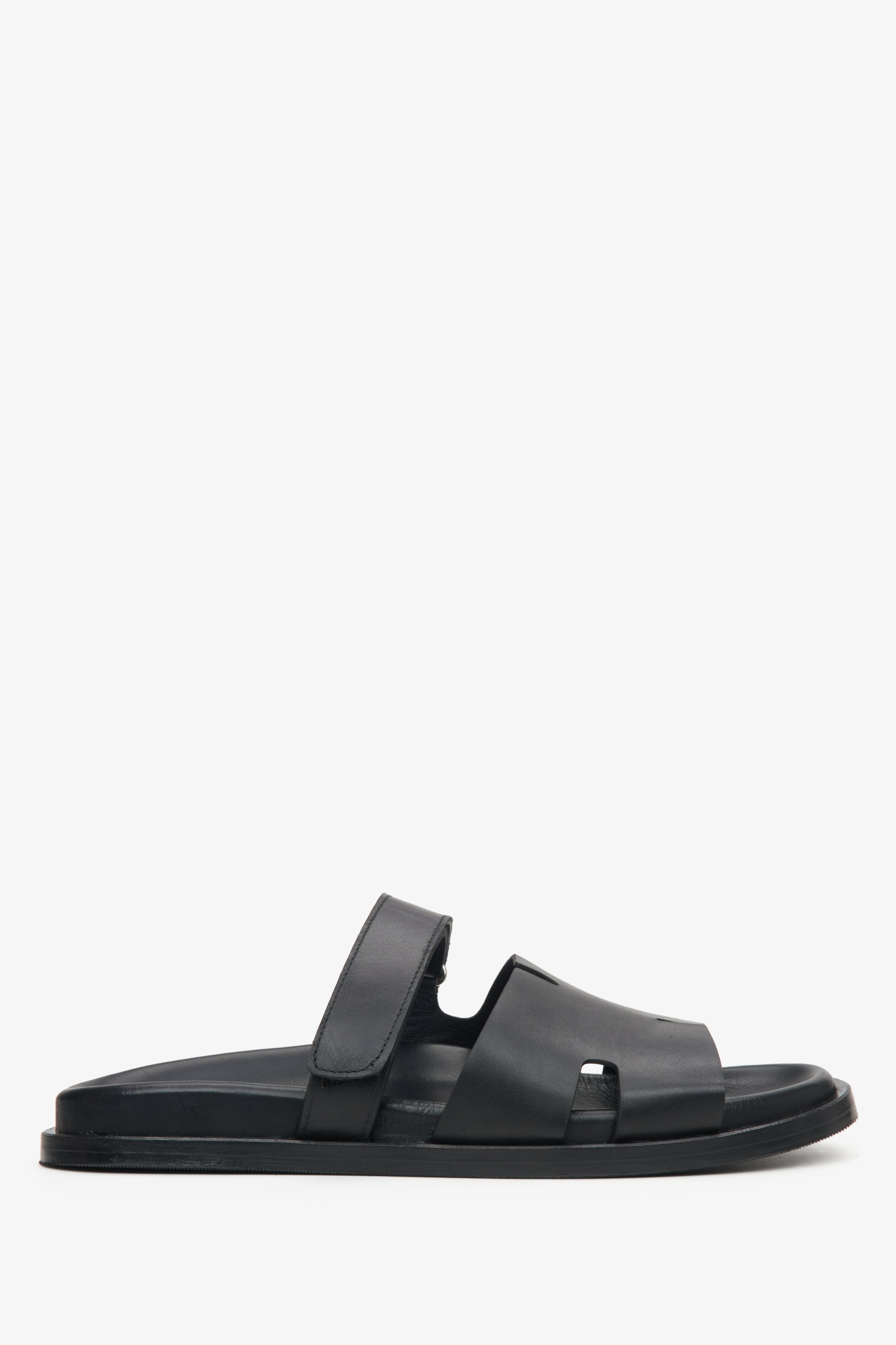 Elegant black leather slip-on sandals with flat sole and leather lining.