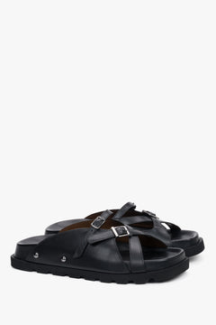 Angled view of women's black leather slide sandals with EVA sole