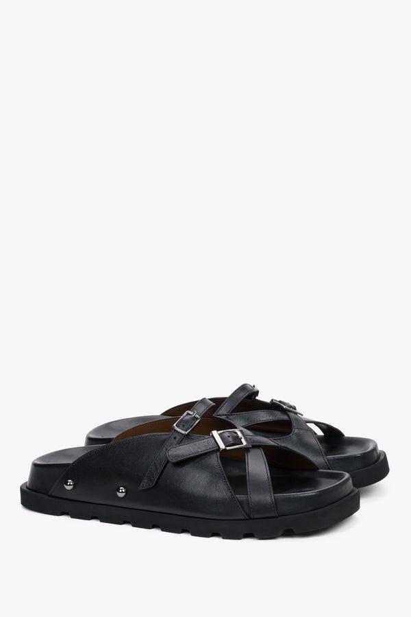 Angled view of women's black leather slide sandals with EVA sole