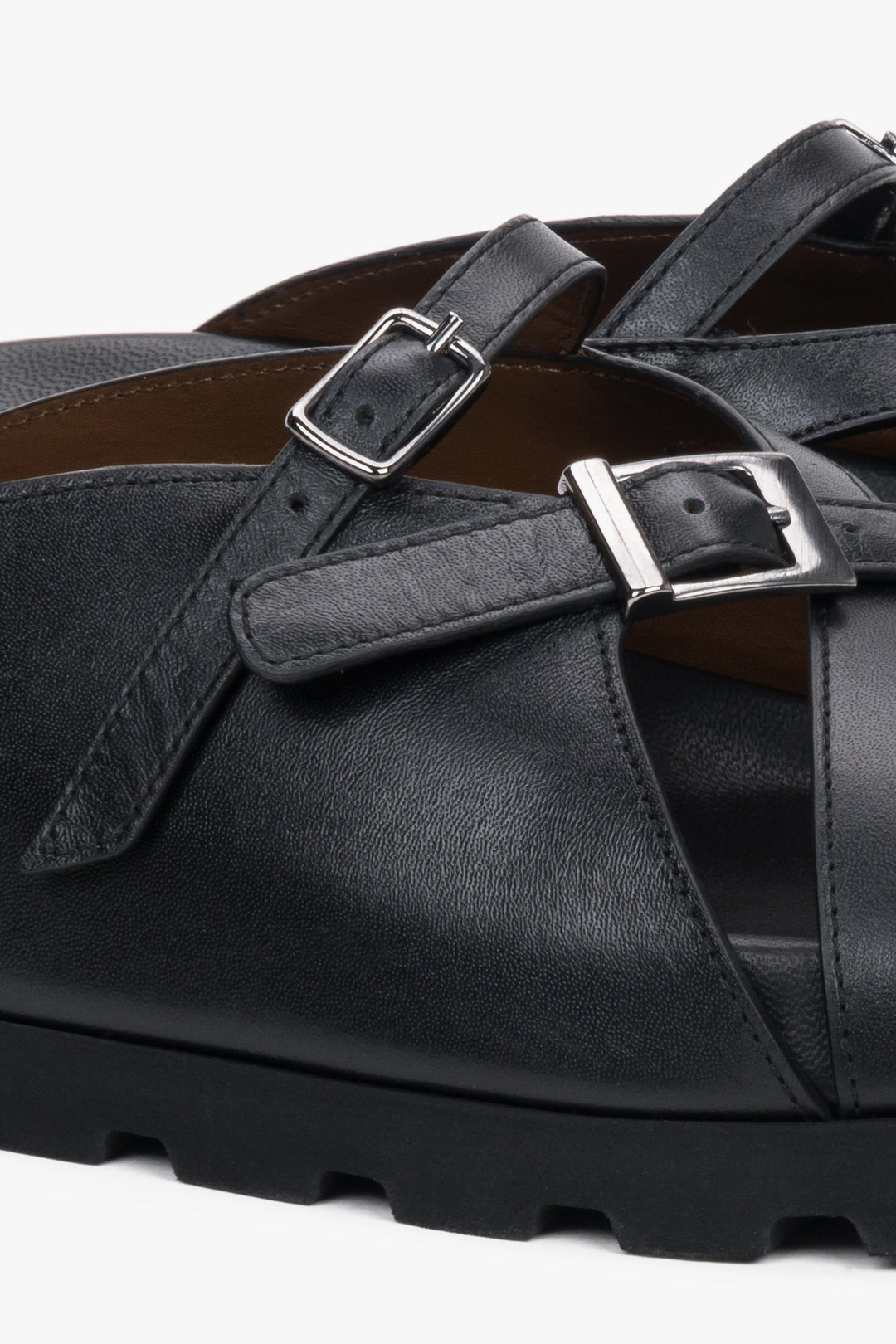 Detail view of silver buckle on black leather Estro slide sandals