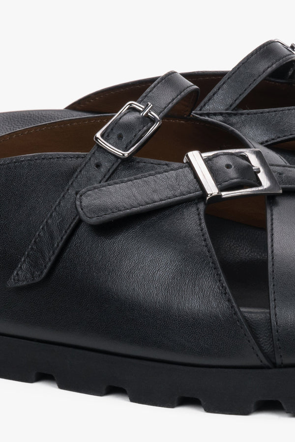 Detail view of silver buckle on black leather Estro slide sandals
