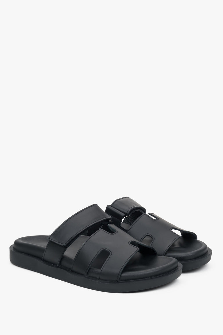 Elegant black slip-on sandals with an adjustable strap.