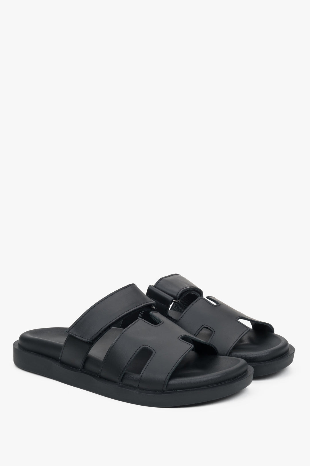 Elegant black slip-on sandals with an adjustable strap.