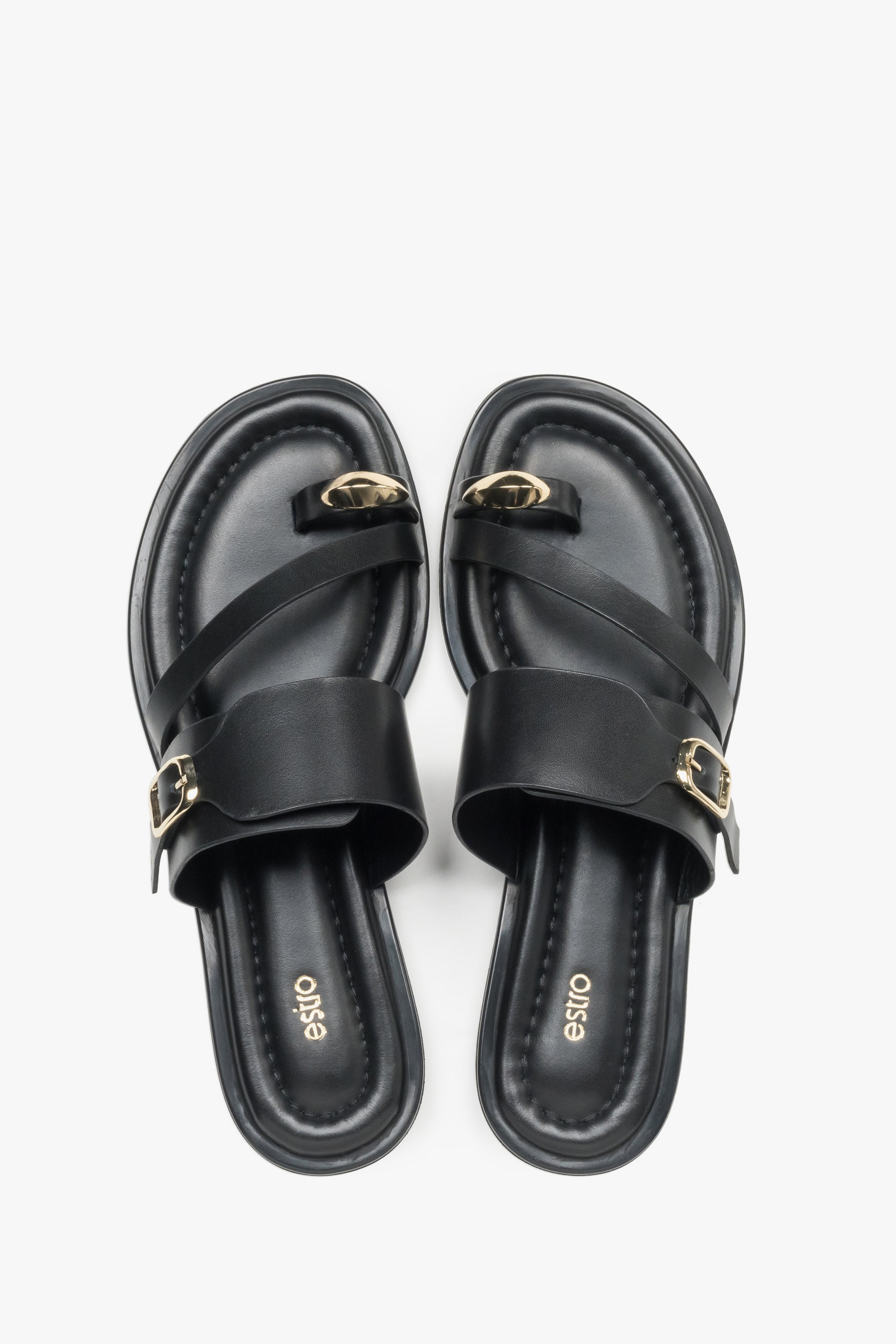 Top view of a pair of shoes showcasing a wide criss-cross strap design, a toe loop for the big toe, and a dark insole featuring the brand logo.