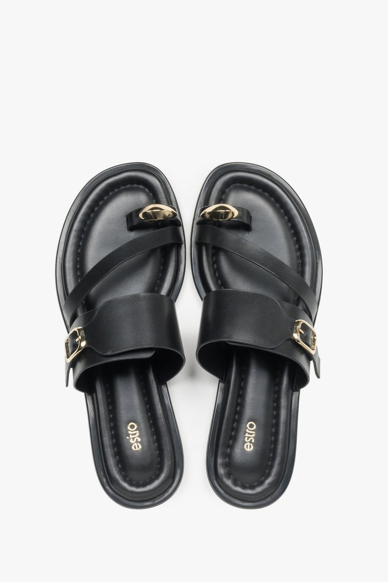 Top view of a pair of shoes showcasing a wide criss-cross strap design, a toe loop for the big toe, and a dark insole featuring the brand logo.