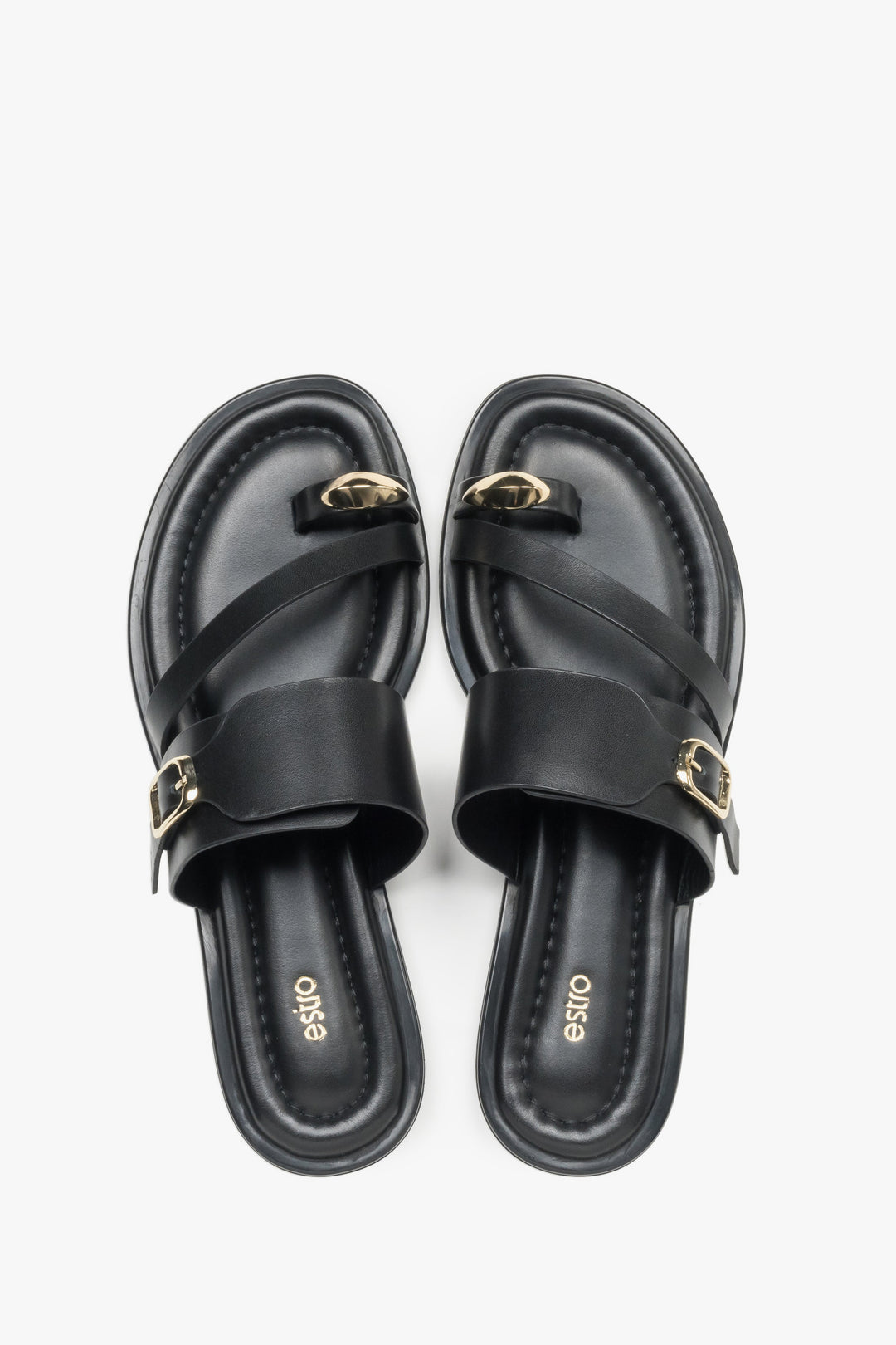 Top view of a pair of shoes showcasing a wide criss-cross strap design, a toe loop for the big toe, and a dark insole featuring the brand logo.