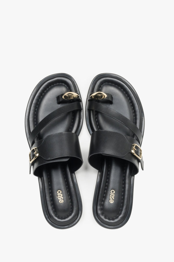 Top view of a pair of shoes showcasing a wide criss-cross strap design, a toe loop for the big toe, and a dark insole featuring the brand logo.