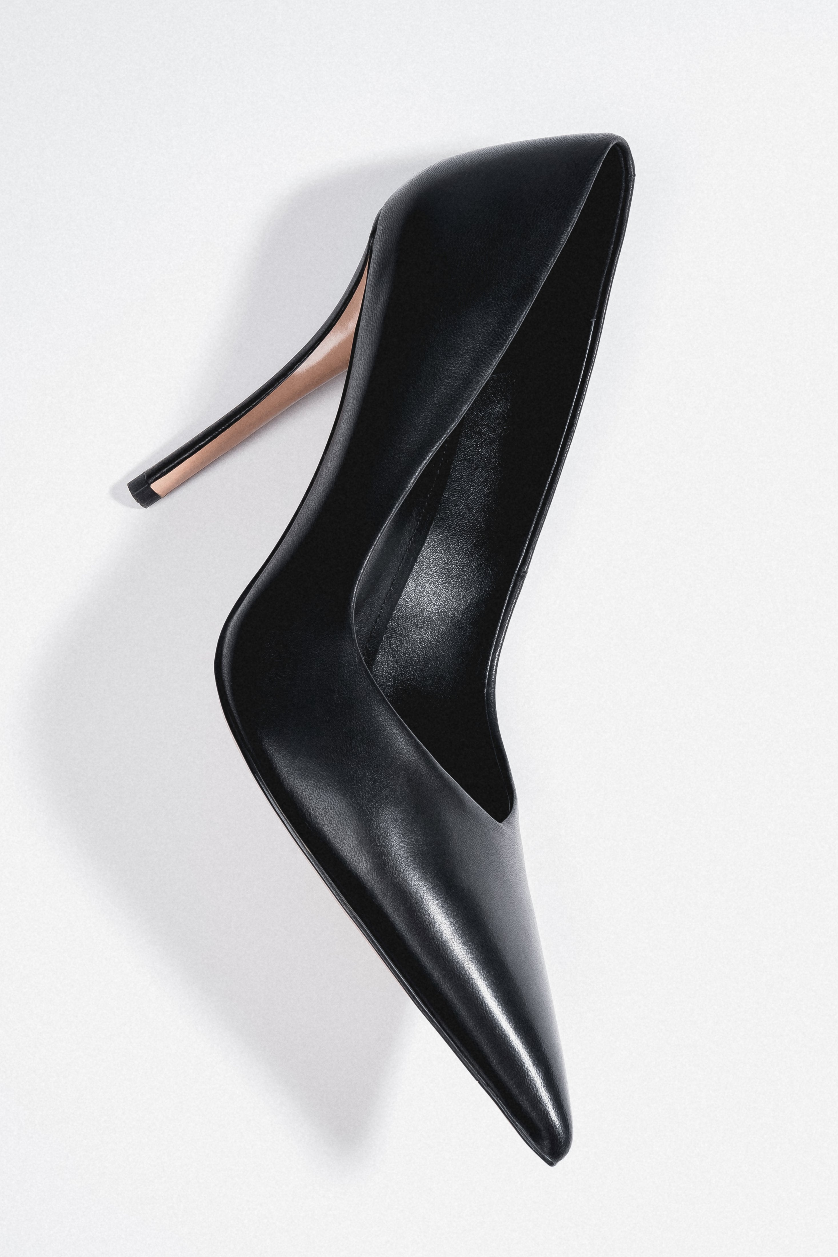 Women's black leather stiletto pumps with a slim heel and a pointed toe by Estro.